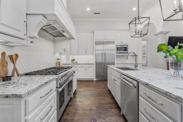 6644 Josephine St, Plano, TX 75024 - kitchen featuring built in appliances, a sink, ornamental molding, dark wood finished floors, and white cabinets