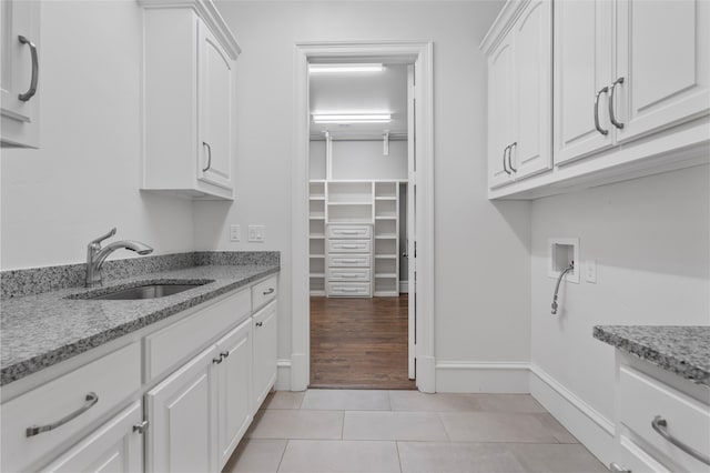 6644 Josephine St, Plano, TX 75024 - laundry room featuring hookup for a washing machine, cabinet space, light tile patterned floors, and baseboards