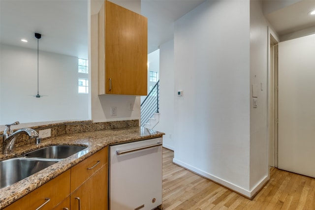 4302 Gilbert Ave, Dallas, TX 75219 - kitchen featuring dishwasher, a sink, brown cabinets, light wood-type flooring, and light stone counters