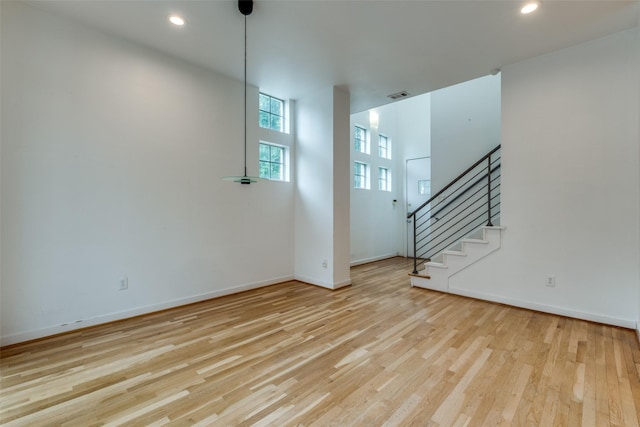 4302 Gilbert Ave, Dallas, TX 75219 - unfurnished living room featuring wood finished floors, stairs, baseboards, and recessed lighting