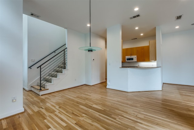 4302 Gilbert Ave, Dallas, TX 75219 - unfurnished living room with light wood-style floors, stairway, baseboards, and recessed lighting