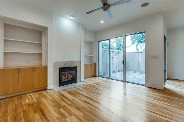 4302 Gilbert Ave, Dallas, TX 75219 - unfurnished living room with ceiling fan, a tile fireplace, light wood-style floors, built in features, and recessed lighting