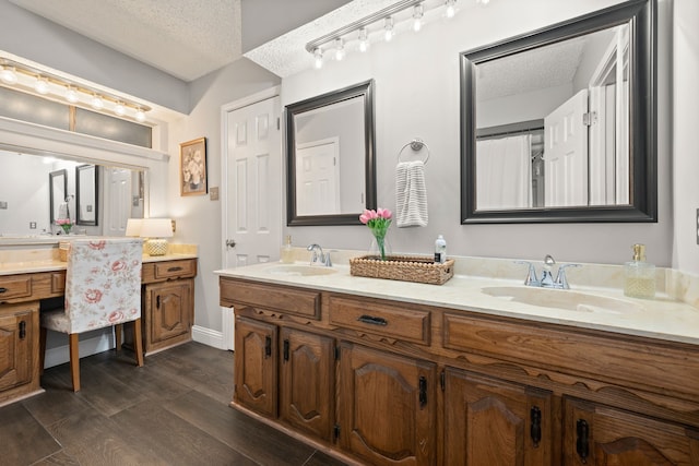7529 Mapleleaf Dr, North Richland Hills, TX 76182 - bathroom featuring double vanity, wood finished floors, a textured ceiling, and baseboards