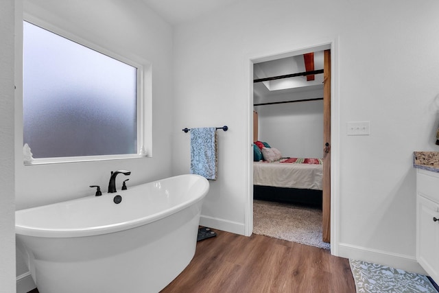 138 Lake Ridge Ct, Abilene, TX 79602 - full bathroom featuring a freestanding bath, vanity, wood finished floors, ensuite bath, and baseboards