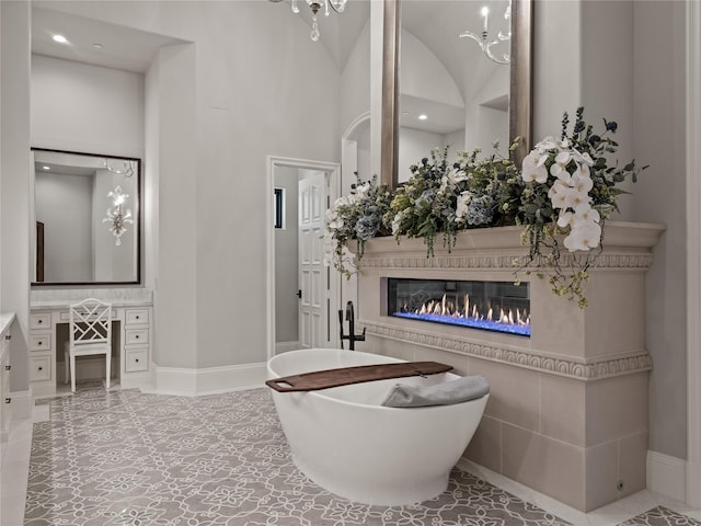 4905 Reserve Ct, Parker, TX 75002 - bathroom with a glass covered fireplace, a freestanding tub, vanity, baseboards, and recessed lighting