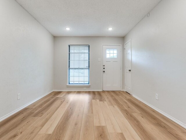 1810 Running River Rd, Garland, TX 75044 - foyer entrance featuring baseboards, a textured ceiling, light wood-type flooring, and recessed lighting