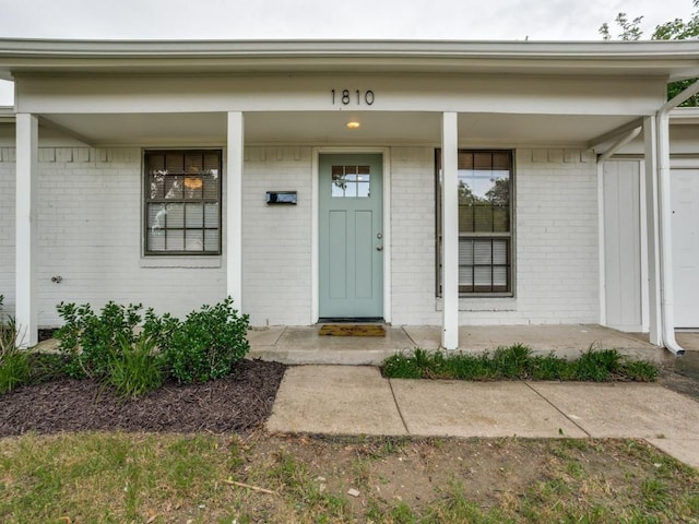 1810 Running River Rd, Garland, TX 75044 - doorway to property with brick siding and a porch