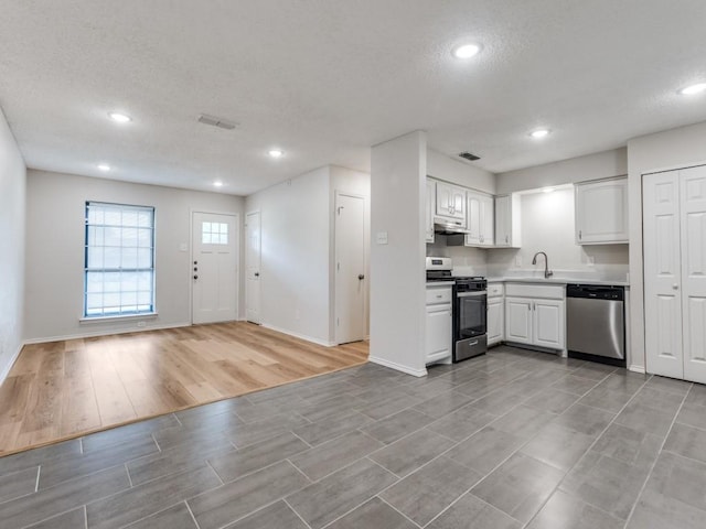 1810 Running River Rd, Garland, TX 75044 - kitchen featuring appliances with stainless steel finishes, wood finish floors, a textured ceiling, white cabinets, and light countertops