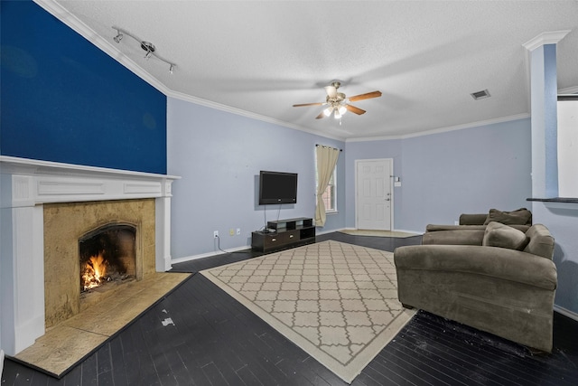 7421 Buckskin Ct, Fort Worth, TX 76137 - living room with a ceiling fan, a textured ceiling, ornamental molding, a premium fireplace, and wood finished floors