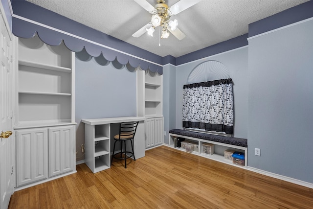 7421 Buckskin Ct, Fort Worth, TX 76137 - office space with ceiling fan, a textured ceiling, built in shelves, wood finished floors, and baseboards