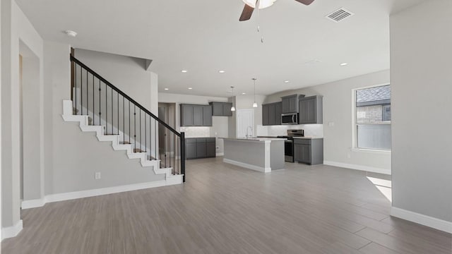 11213 Orchard Ln, Justin, TX 76247 - unfurnished living room featuring wood finished floors, a ceiling fan, baseboards, recessed lighting, and stairway