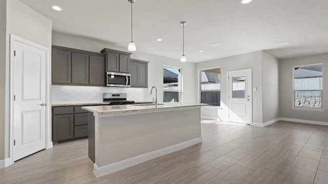 11213 Orchard Ln, Justin, TX 76247 - kitchen featuring appliances with stainless steel finishes, a sink, healthy amount of natural light, tasteful backsplash, and recessed lighting