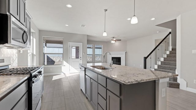11213 Orchard Ln, Justin, TX 76247 - kitchen featuring stainless steel appliances, a sink, open floor plan, baseboards, and recessed lighting