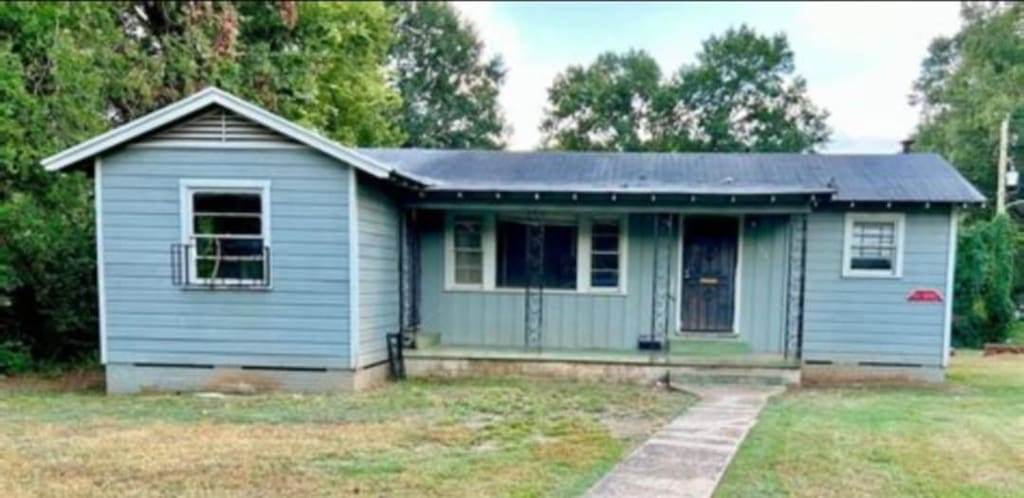 3551 W College St, Shreveport, LA 71109 - view of front of home featuring a porch, a front lawn, crawl space, and board and batten siding
