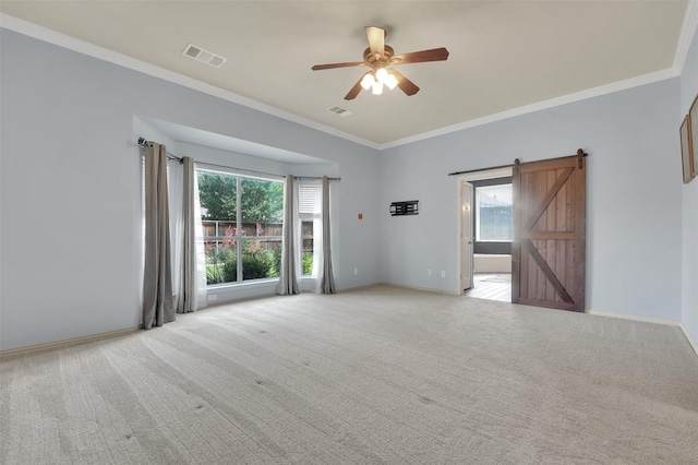 621 Maize Rd, Murphy, TX 75094 - empty room featuring a barn door, ceiling fan, healthy amount of natural light, ornamental molding, and light colored carpet