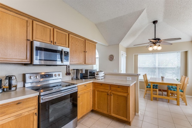 2401 Loon Lake Rd, Denton, TX 76210 - kitchen featuring stainless steel appliances, a peninsula, light tile patterned floors, a ceiling fan, and light countertops