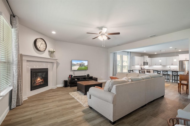 1713 Brindle St, Justin, TX 76247 - living room with a ceiling fan, a tile fireplace, light wood-type flooring, recessed lighting, and baseboards