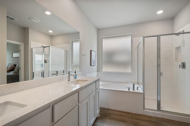 1713 Brindle St, Justin, TX 76247 - full bath featuring wood finished floors, a garden tub, a stall shower, double vanity, and recessed lighting
