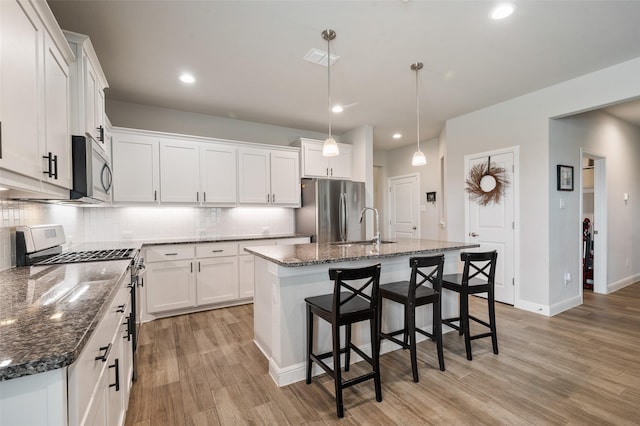 1713 Brindle St, Justin, TX 76247 - kitchen featuring stainless steel appliances, decorative backsplash, a sink, light wood-style floors, and recessed lighting