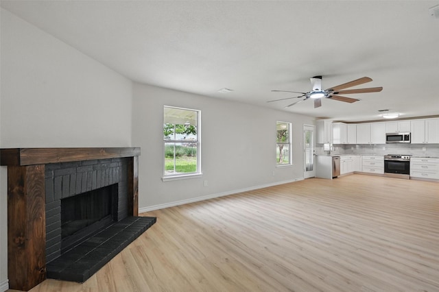 1126 Mazourka Dr, Arlington, TX 76001 - unfurnished living room with light wood-style flooring, healthy amount of natural light, a ceiling fan, and baseboards