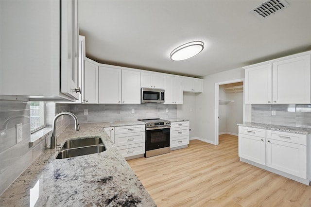 1126 Mazourka Dr, Arlington, TX 76001 - kitchen featuring stainless steel appliances, a sink, backsplash, and light stone counters
