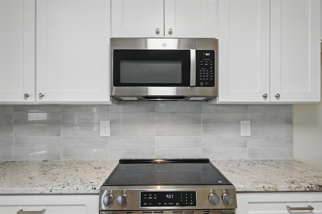 1126 Mazourka Dr, Arlington, TX 76001 - kitchen with appliances with stainless steel finishes, decorative backsplash, white cabinets, and light stone counters