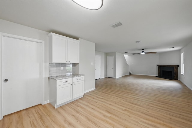 1126 Mazourka Dr, Arlington, TX 76001 - unfurnished living room with light wood-style floors, a ceiling fan, a fireplace with raised hearth, and baseboards