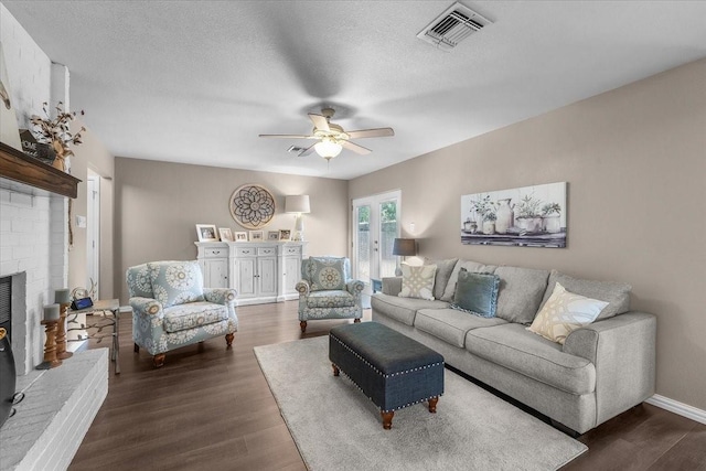 1210 Kay Dr, Weatherford, TX 76086 - living room with a ceiling fan, wood finished floors, a brick fireplace, baseboards, and a textured ceiling