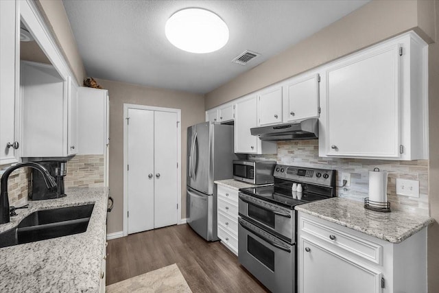 1210 Kay Dr, Weatherford, TX 76086 - kitchen featuring appliances with stainless steel finishes, under cabinet range hood, a sink, white cabinets, and dark wood-type flooring