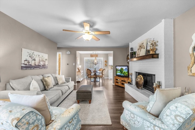 1210 Kay Dr, Weatherford, TX 76086 - living room with a ceiling fan, dark wood-style flooring, a brick fireplace, and baseboards