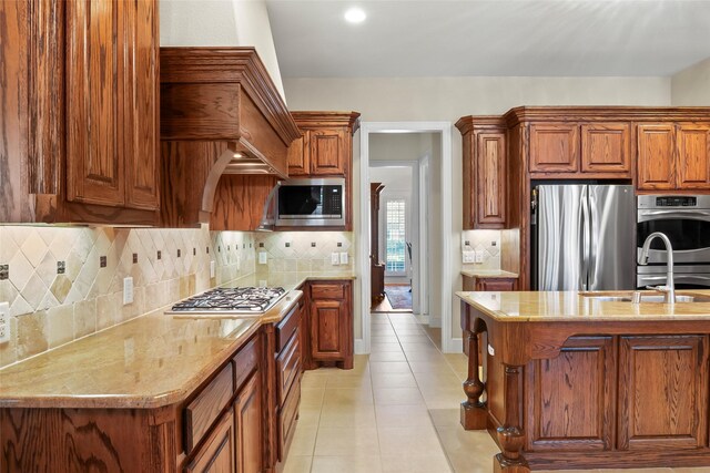 4211 Wilson Creek Trl, Prosper, TX 75078 - kitchen with appliances with stainless steel finishes, brown cabinetry, light tile patterned flooring, and light stone countertops