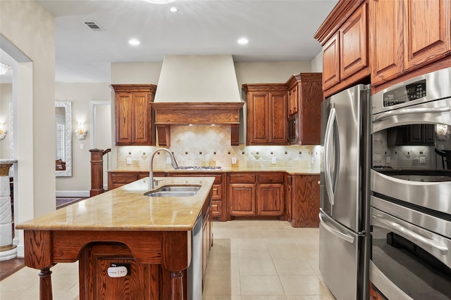 4211 Wilson Creek Trl, Prosper, TX 75078 - kitchen with appliances with stainless steel finishes, wall chimney exhaust hood, a sink, light stone countertops, and brown cabinetry
