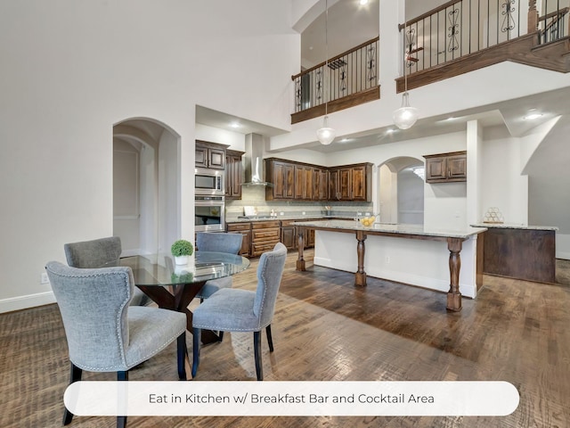 4603 Whitestone Dr, Parker, TX 75002 - dining space with arched walkways, dark wood-type flooring, and a towering ceiling