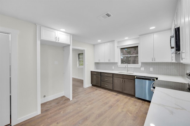 7401 Trimble Dr, Fort Worth, TX 76134 - kitchen with stainless steel dishwasher, a sink, backsplash, white cabinetry, and recessed lighting