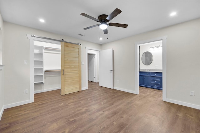 7401 Trimble Dr, Fort Worth, TX 76134 - unfurnished bedroom with baseboards, wood finished floors, a spacious closet, ensuite bath, and recessed lighting
