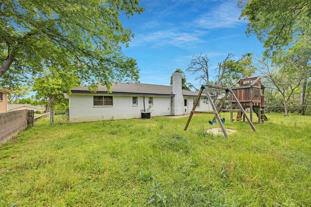 7401 Trimble Dr, Fort Worth, TX 76134 - rear view of property with a playground, a chimney, brick siding, and central AC
