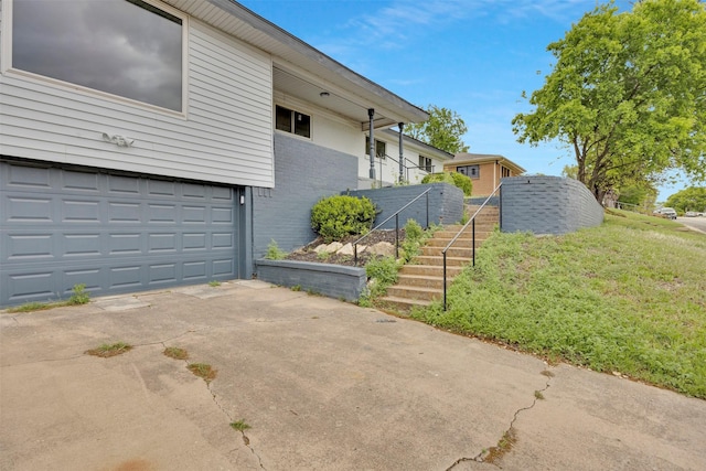 7401 Trimble Dr, Fort Worth, TX 76134 - view of home's exterior with stairway, an attached garage, brick siding, and driveway