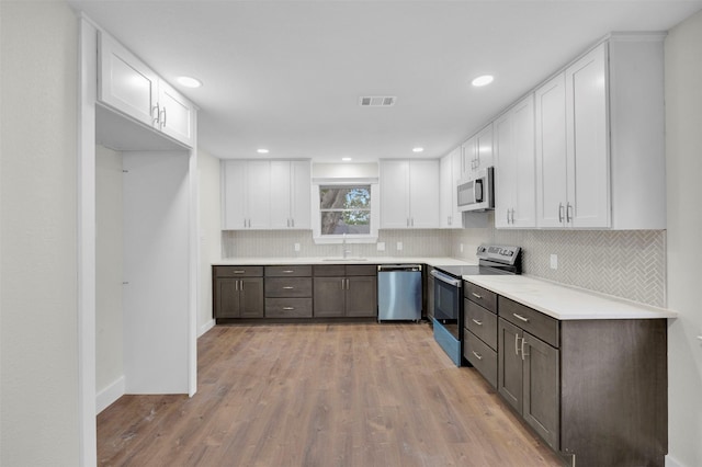 7401 Trimble Dr, Fort Worth, TX 76134 - kitchen with appliances with stainless steel finishes, white cabinetry, a sink, tasteful backsplash, and recessed lighting