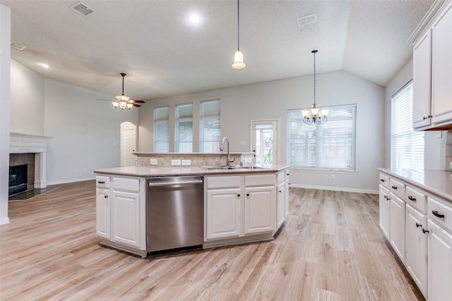 7491 Daffodil Way, Frisco, TX 75033 - kitchen with stainless steel dishwasher, a sink, light wood-style flooring, light countertops, and vaulted ceiling