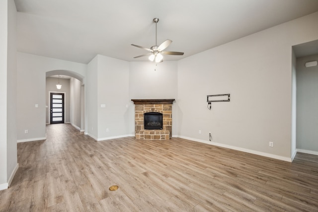 1529 Calcot Ln, Forney, TX 75126 - unfurnished living room with ceiling fan, wood finished floors, arched walkways, baseboards, and a fireplace