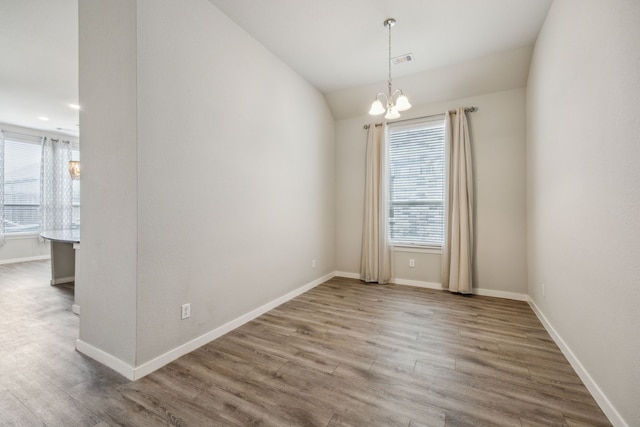 1529 Calcot Ln, Forney, TX 75126 - empty room with a chandelier, wood finished floors, baseboards, and lofted ceiling