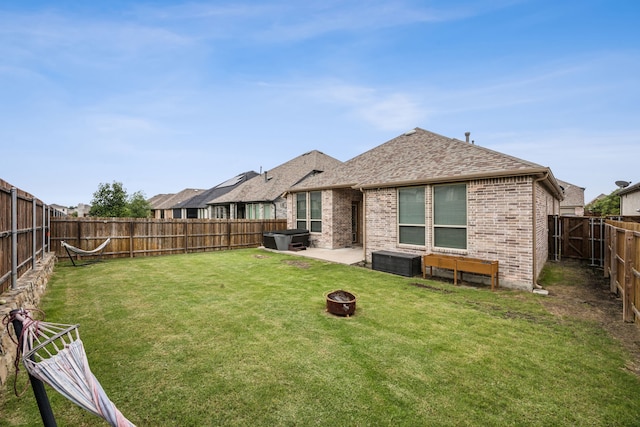1529 Calcot Ln, Forney, TX 75126 - rear view of house with an outdoor fire pit, brick siding, a patio, and a shingled roof