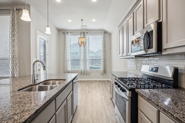 1529 Calcot Ln, Forney, TX 75126 - kitchen featuring appliances with stainless steel finishes, a sink, light wood-style floors, backsplash, and dark stone counters