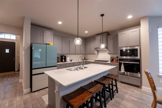 3036 Lionsgate Dr, Argyle, TX 76226 - kitchen featuring appliances with stainless steel finishes, a sink, light wood finished floors, gray cabinets, and recessed lighting