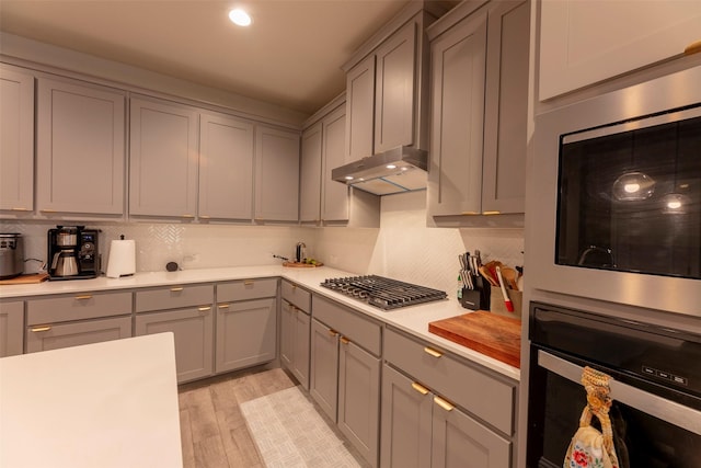 3036 Lionsgate Dr, Argyle, TX 76226 - kitchen with appliances with stainless steel finishes, gray cabinetry, under cabinet range hood, light countertops, and decorative backsplash