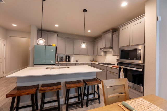 3036 Lionsgate Dr, Argyle, TX 76226 - kitchen featuring appliances with stainless steel finishes, gray cabinetry, under cabinet range hood, recessed lighting, and a sink
