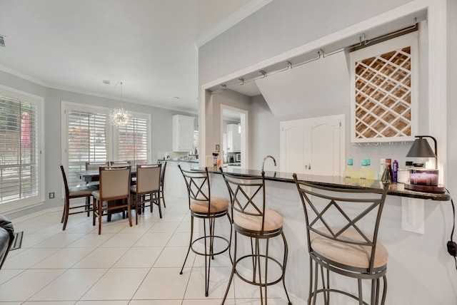 2805 Pine View Dr, Grapevine, TX 76051 - kitchen featuring ornamental molding, a chandelier, a kitchen bar, a peninsula, and dark countertops