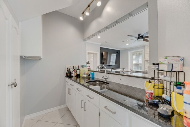2805 Pine View Dr, Grapevine, TX 76051 - kitchen featuring a sink, a ceiling fan, dark stone counters, light tile patterned flooring, and ornamental molding