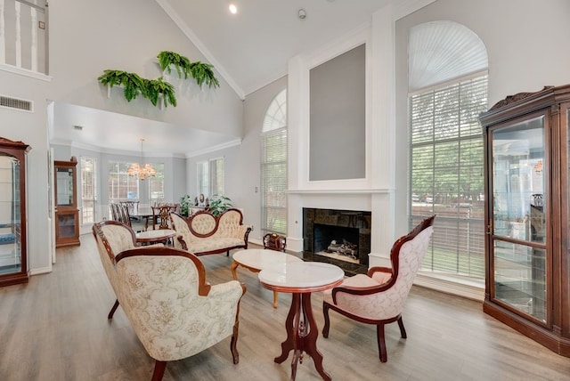 2805 Pine View Dr, Grapevine, TX 76051 - living room with high vaulted ceiling, crown molding, a stone fireplace, light wood-style flooring, and a chandelier