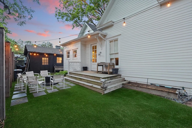 505 N College St, Mckinney, TX 75069 - back of house at dusk with a wooden deck and a yard